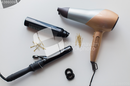 Image of hairdryer, styler or curling iron and hair spray