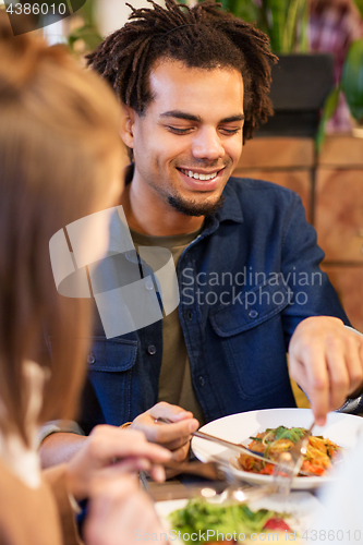 Image of happy couple eating at restaurant