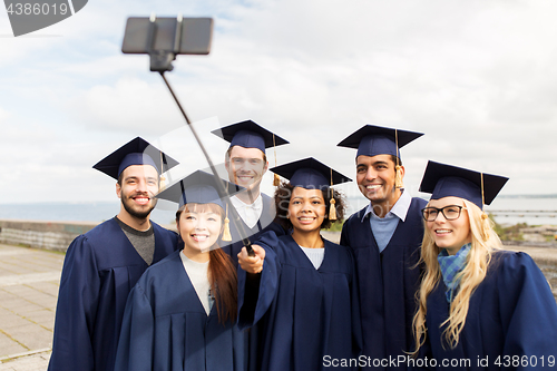 Image of group of happy students or graduates taking selfie