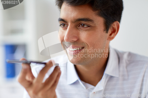 Image of close up of man using voice recorder on smartphone