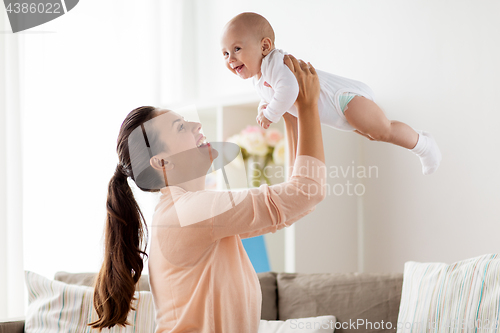 Image of happy mother playing with little baby boy at home