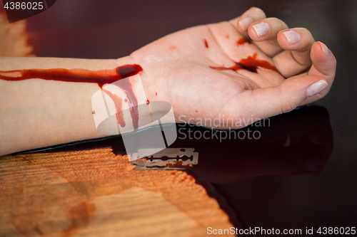 Image of dead woman hand in blood on floor at crime scene