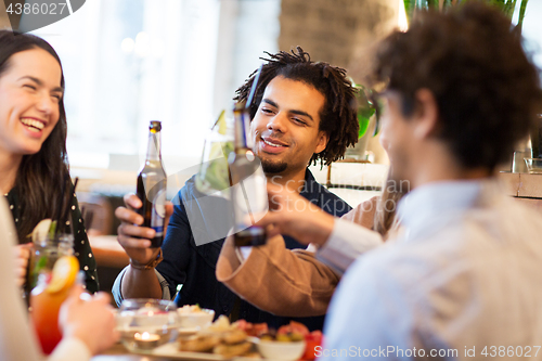 Image of happy friends drinking non alcoholic beer at bar