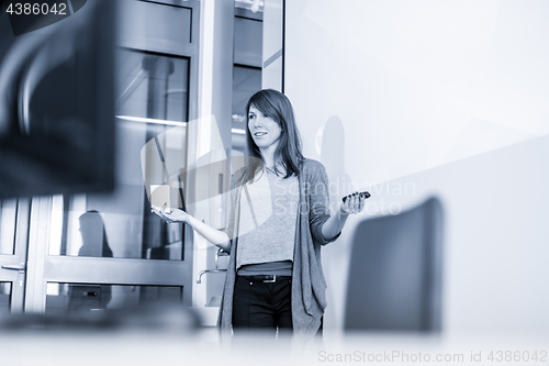 Image of Woman giving presentation in lecture hall at university.