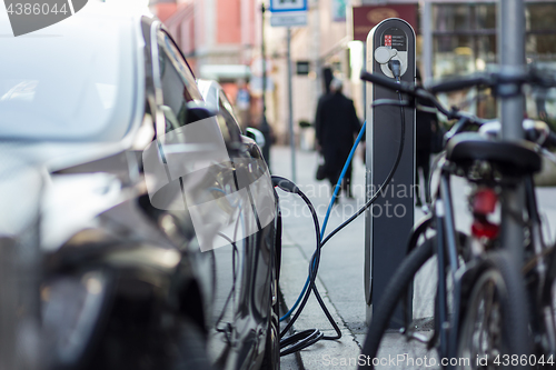 Image of Charging modern electric car on the street as future of automotive industry.