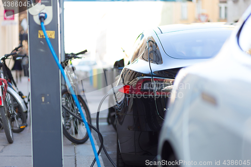 Image of Charging modern electric car on the street as future of automotive industry.