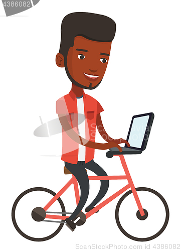 Image of Man riding bicycle and working on a laptop.