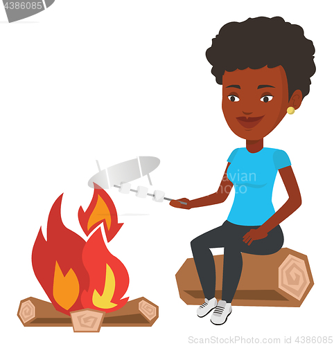 Image of Woman roasting marshmallow over campfire.