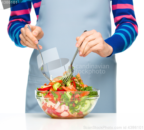 Image of Cook is mixing salad