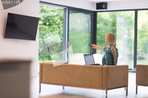 Image of Young woman using laptop at home