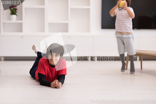 Image of boys having fun with an apple on the floor