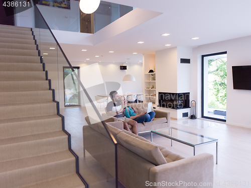 Image of young happy couple relaxes in the living room