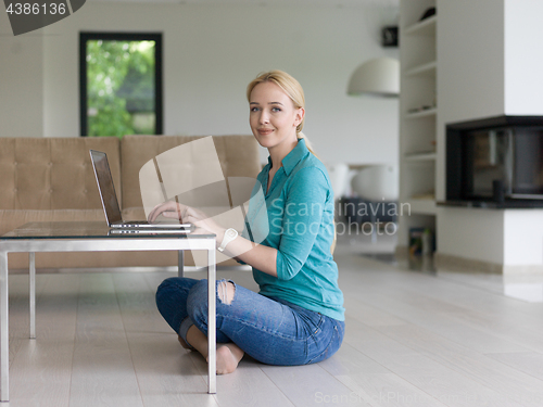 Image of young women using laptop computer on the floor