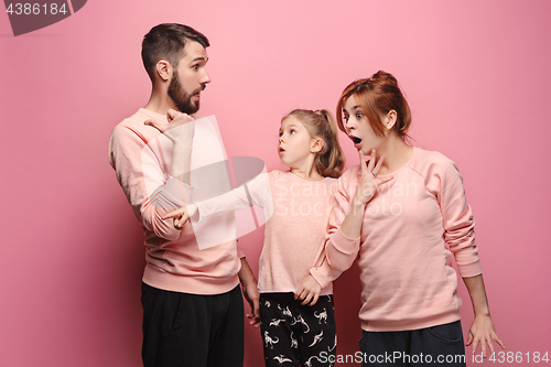 Image of Surprised young family on pink