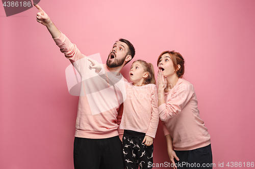 Image of Surprised young family on pink