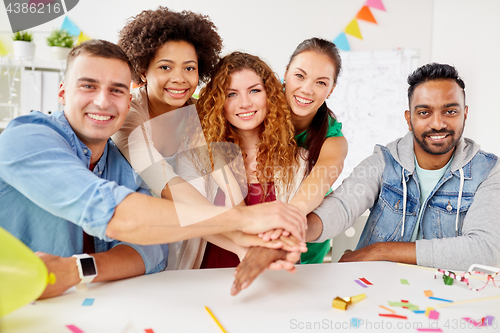 Image of happy business team at office party holding hands