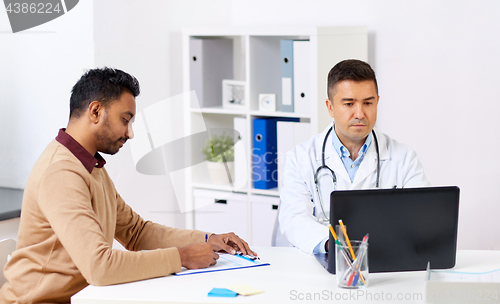 Image of doctor with laptop and male patient at hospital