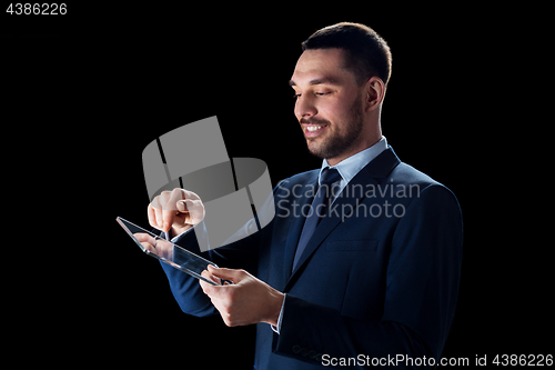 Image of businessman in suit with transparent tablet pc