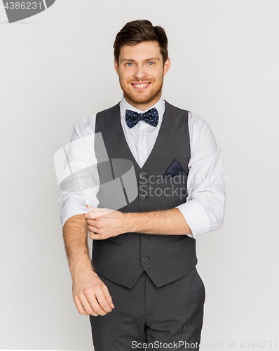 Image of happy man in festive suit dressing for party