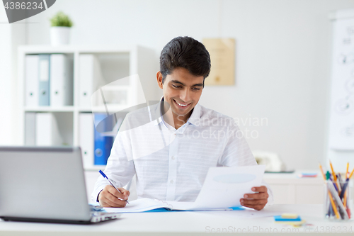 Image of businessman working with papers at office