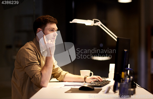 Image of man calling on smartphone late at night office