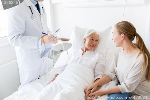 Image of senior woman and doctor with clipboard at hospital