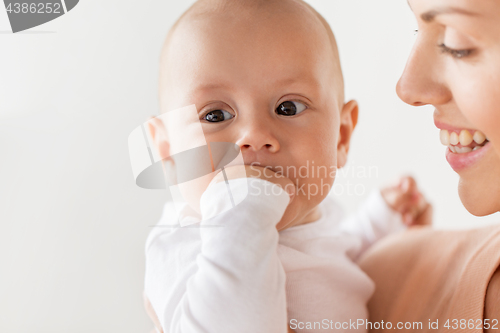 Image of happy mother with little baby boy sucking fingers