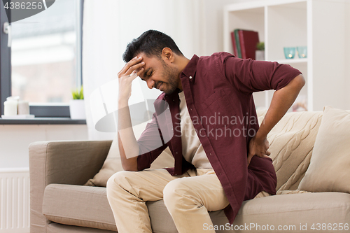 Image of unhappy man suffering from backache at home