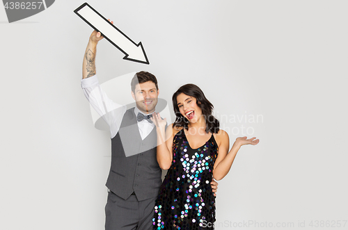 Image of happy couple with big arrow at party