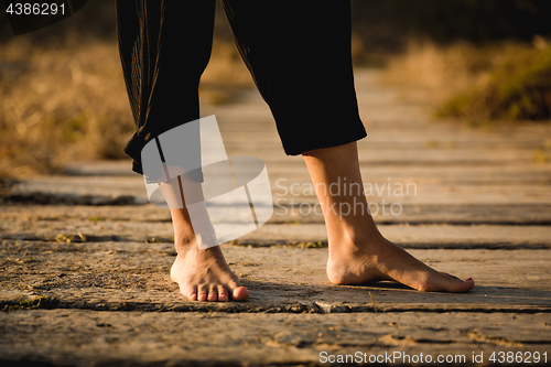 Image of Female legs on a wood path