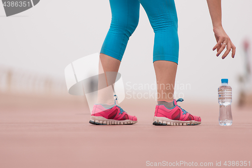 Image of close up on running shoes and bottle of water