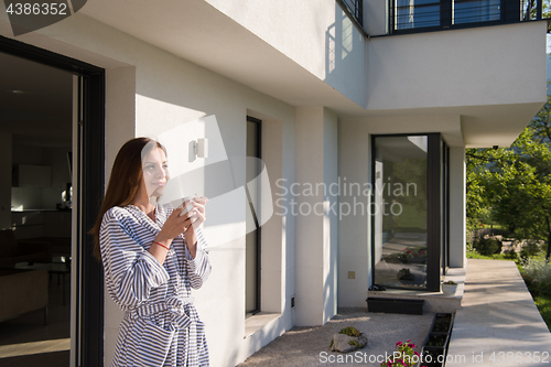Image of woman in a bathrobe enjoying morning coffee