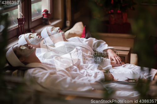 Image of women is getting facial clay mask at spa