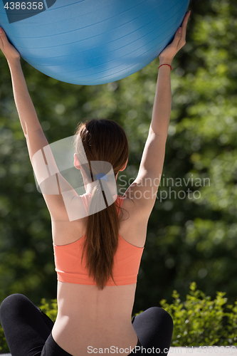 Image of woman doing exercise with pilates ball