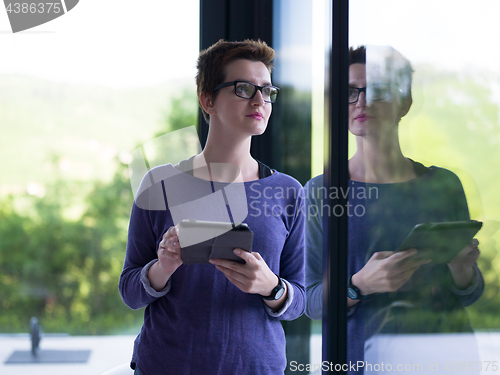 Image of young women using tablet computer by the window