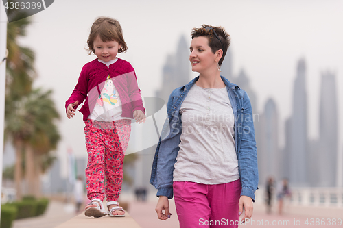 Image of mother and cute little girl on the promenade