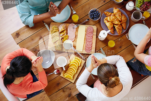 Image of group of people at table praying before meal