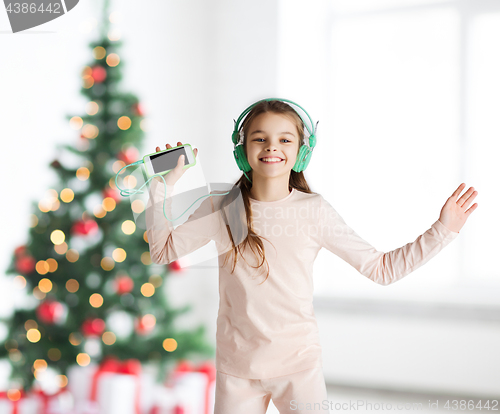 Image of girl with smartphone and headphones at christmas