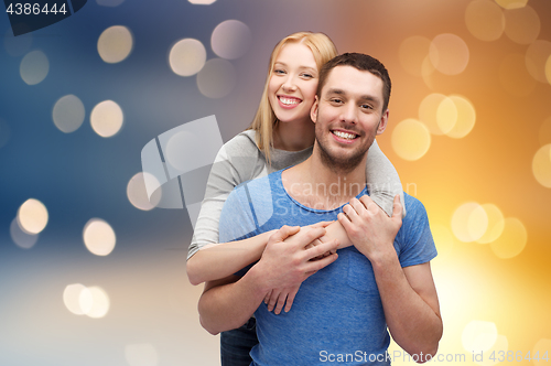 Image of happy couple hugging over lights background