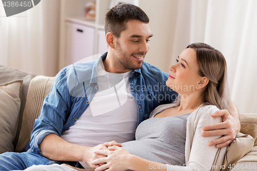 Image of man hugging pregnant woman at home