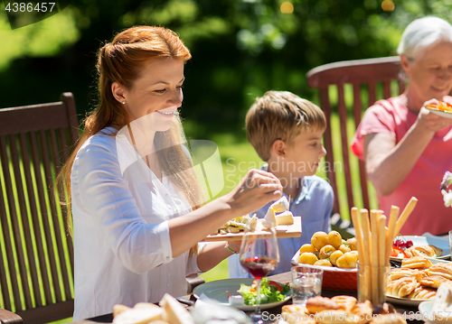 Image of happy family having dinner or summer garden party