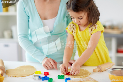 Image of happy mother and daughter making cookies at home