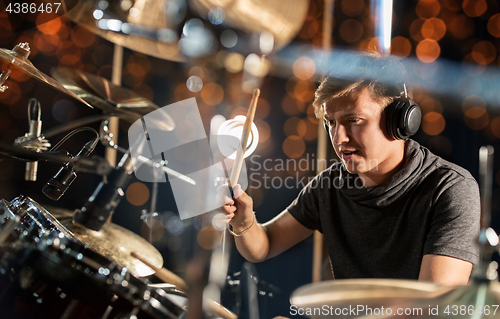 Image of male musician playing drum kit at concert