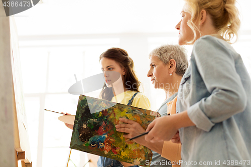Image of women with brushes painting at art school
