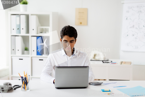 Image of businessman with laptop working at office