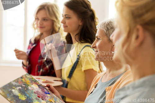 Image of women with brushes painting at art school