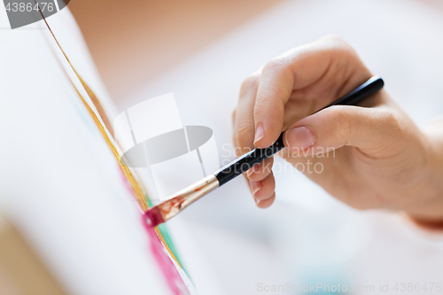 Image of hand of artist with brush painting picture