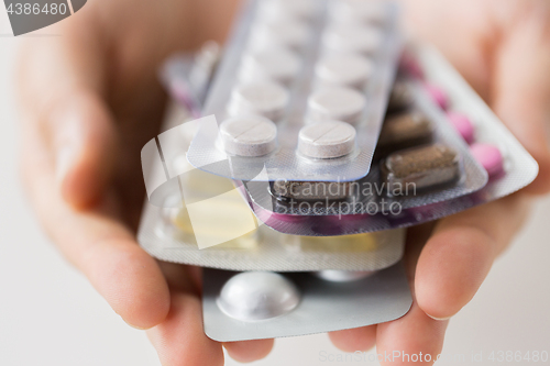 Image of woman hands holding packs of pills