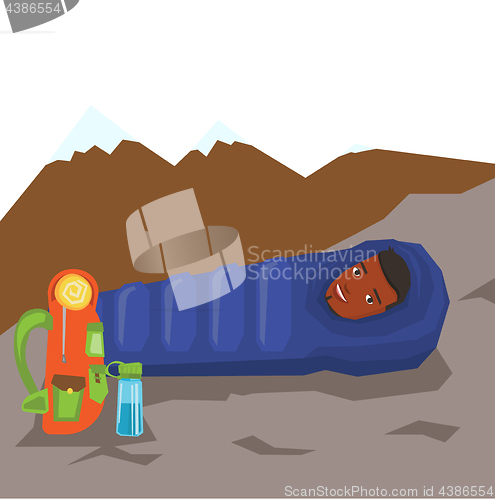 Image of Man resting in sleeping bag in the mountains.
