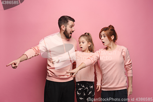Image of Surprised young family on pink